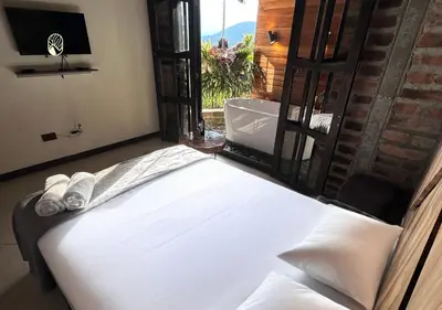 a bedroom with a bed with a view of a window at Finca Hotel Tierra Verde in Girardota