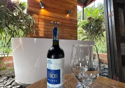 a bottle of wine and a glass on a table at Finca Hotel Tierra Verde in Girardota