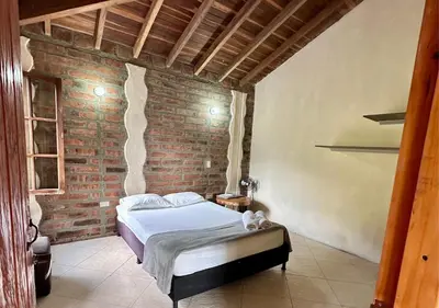 a bedroom with a bed in a brick wall at Finca Hotel Tierra Verde in Girardota
