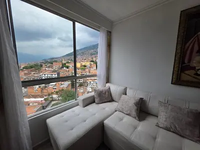 a white couch in a room with a large window at Apartamento vistas lindas cerca centro in Medellín