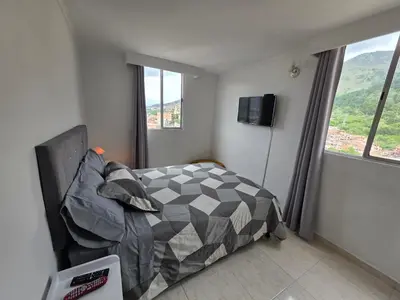 a bedroom with a bed and a couch and windows at Apartamento vistas lindas cerca centro in Medellín