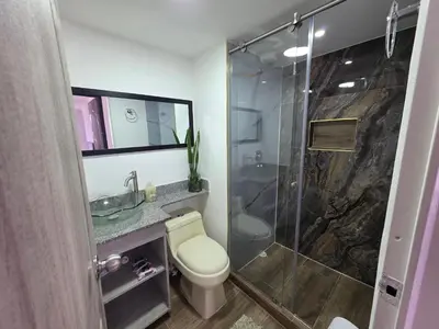 a bathroom with a toilet and a glass shower at Apartamento vistas lindas cerca centro in Medellín