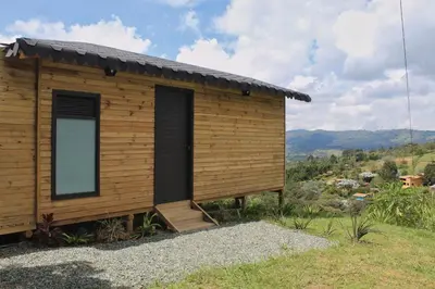a wooden cabin with a window on a hill at Glamping con jacuzzi cerca a Medellin in Guarne