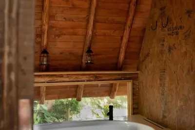 a bathroom with a bath tub and a window at Glamping con jacuzzi cerca a Medellin in Guarne