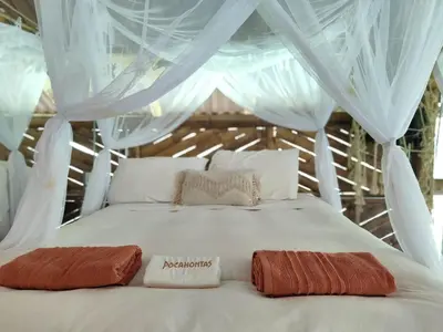 a white bed with two towels on top of it at Ecocabaña Pocahontas en rio Santo Domingo, Melcocho in Cocorná