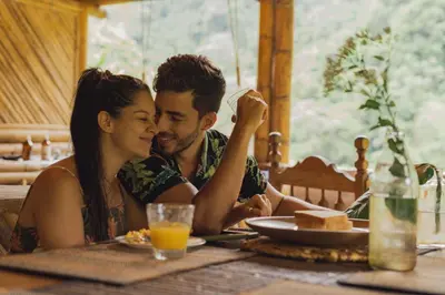 a man and a woman sitting at a table at Ecocabaña Pocahontas en rio Santo Domingo, Melcocho in Cocorná