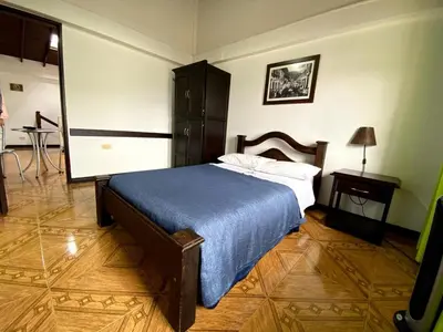 a bedroom with a bed with a blue blanket on it at Hospedaje Casa Real in Salamina