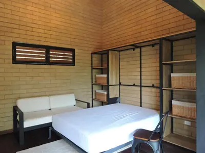 a room with a bed and a bench and shelves at Palagua Lodge in San Rafael