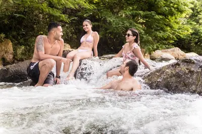 a group of people sitting on rocks in a river at Palagua Lodge in San Rafael