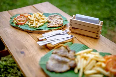 a wooden table with plates of food on it at Paraíso Escondido Cabañas, Reserva Rio Claro, San Luis-Doradal in San Luis