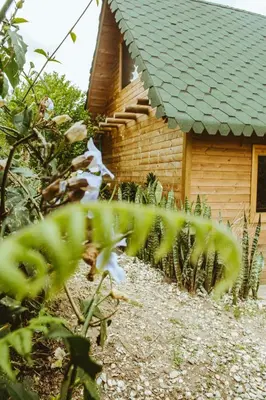a wooden house with a green roof at Guané Glamping Ecolodge Jacuzzi Privado Oriente Antioqueño in Guarne
