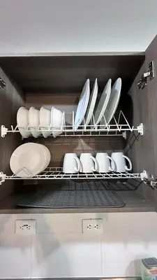 a bunch of plates and bowls on a shelf in a kitchen at APTO AMOBLADO 77 mt2 in Itagüí