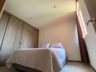 a small bedroom with a bed and a window at APTO AMOBLADO 77 mt2 in Itagüí