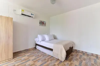 a bedroom with a bed in a room at CABAÑAS LA DORADA in Doradal