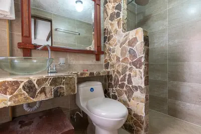 a bathroom with a toilet and a sink at CABAÑAS LA DORADA in Doradal
