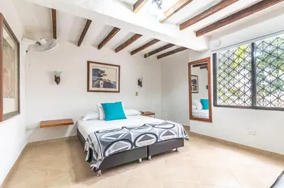 a bedroom with a bed and a large window at CABAÑAS LA DORADA in Doradal