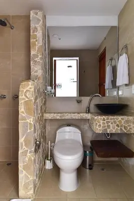 a bathroom with a white toilet and a sink at CABAÑAS LA DORADA in Doradal