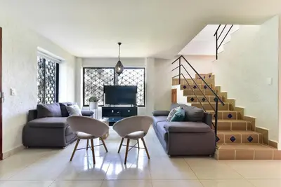 a living room with a couch and a table and chairs at CABAÑAS LA DORADA in Doradal