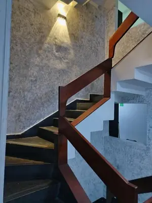 a stairwell with a wooden rail and a light at Hotel Country Medellin in Medellín
