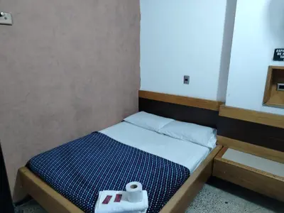 a small bedroom with a bed with a towel on it at Hotel Country Medellin in Medellín