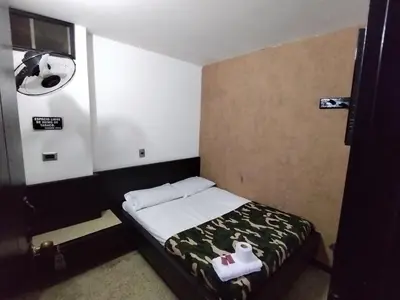 a small room with a bed in a room with avertisement at Hotel Country Medellin in Medellín