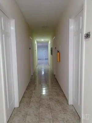 an empty hallway with white walls and a tile floor at HOTEL CALLE REAL SUITE in Medellín
