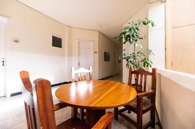 a dining room with a wooden table and chairs at HOTEL CALLE REAL SUITE in Medellín