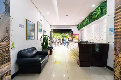 a lobby of a restaurant with a black leather chair at HOTEL CALLE REAL SUITE in Medellín