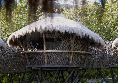a straw roofed bird house on a stand at Hotel Casa Candela in San Jerónimo