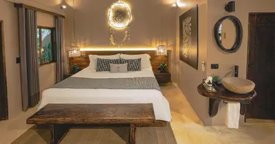 a bedroom with a large bed and a wooden table at Hotel Casa Candela in San Jerónimo