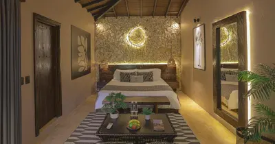 a bedroom with a bed and a table in it at Hotel Casa Candela in San Jerónimo