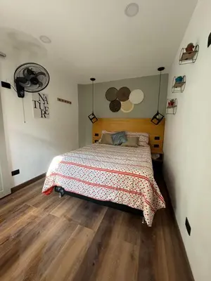a bedroom with a bed and a wooden floor at Hostal Pura Vida la 70 in Medellín