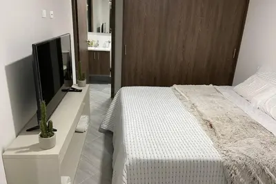a bedroom with a bed and a television on a counter at Hermoso Apartaestudio en Sabaneta. in Sabaneta