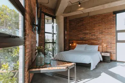 a brick walled bedroom with a bed and a table at Hotel 3450 Living Lofts in Medellín