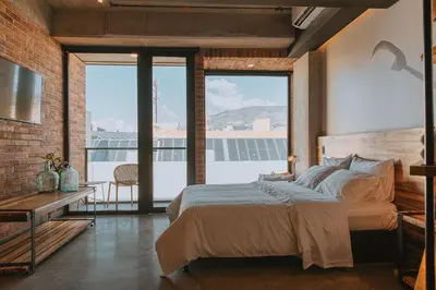a bedroom with a bed and a large window at Hotel 3450 Living Lofts in Medellín
