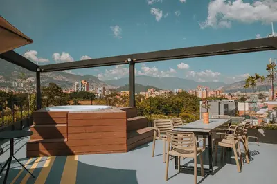 a table and chairs on a balcony with a view of a city at Hotel 3450 Living Lofts in Medellín