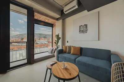 a living room with a blue couch and a table at Hotel 3450 Living Lofts in Medellín