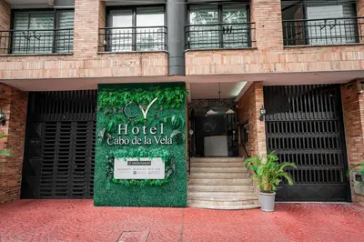 a hotel building with a sign in front of it at Hotel Cabo de la Vela Medellin in Medellín
