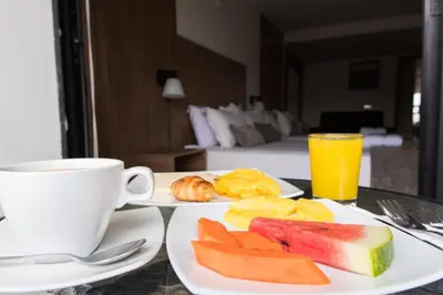 a table with two plates of food and a cup of coffee at Hotel Cabo de la Vela Medellin in Medellín