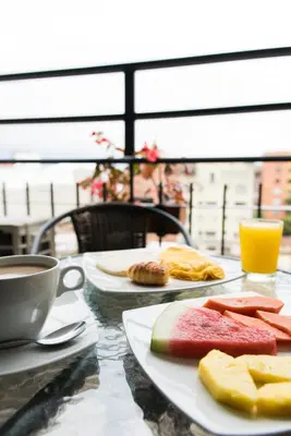 a table with two plates of food and a cup of coffee at Hotel Cabo de la Vela Medellin in Medellín