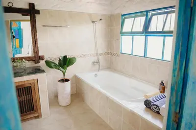 a bathroom with a tub and a potted plant at Hotel Kalma in Santa Fe de Antioquia