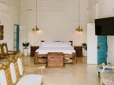 a bedroom with a bed and a table and chairs at Hotel Kalma in Santa Fe de Antioquia