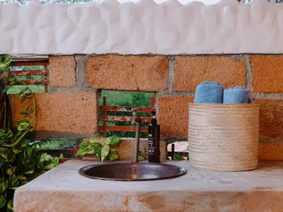 a bathroom sink with a bottle of wine and towels at Hotel Kalma in Santa Fe de Antioquia