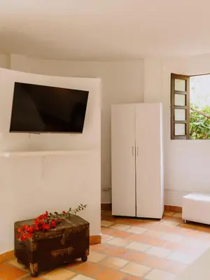 a living room with a tv and a chest at Hotel Kalma in Santa Fe de Antioquia