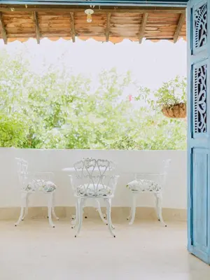 two white chairs and a table on a patio at Hotel Kalma in Santa Fe de Antioquia