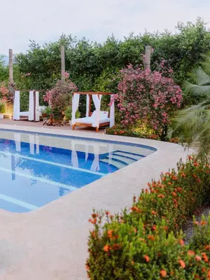 a swimming pool with a chair and some flowers at Hotel Kalma in Santa Fe de Antioquia
