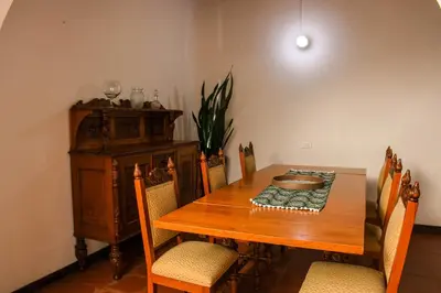 a dining room with a wooden table and chairs at La Casa de Ana in Jardin