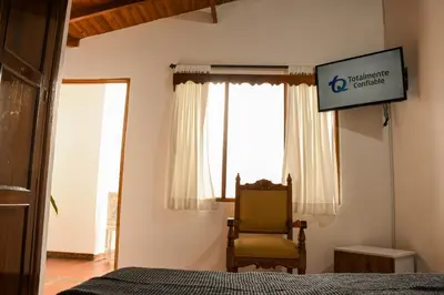 a bedroom with a bed and a chair and a sign at La Casa de Ana in Jardin