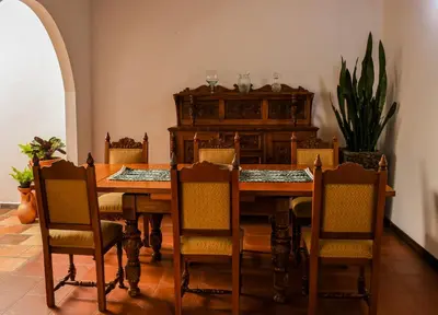 a dining room with a wooden table and chairs at La Casa de Ana in Jardin