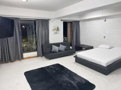 a bedroom with a bed and a couch at Apartamentos Tipo Loft Parque del Poblado in Medellín